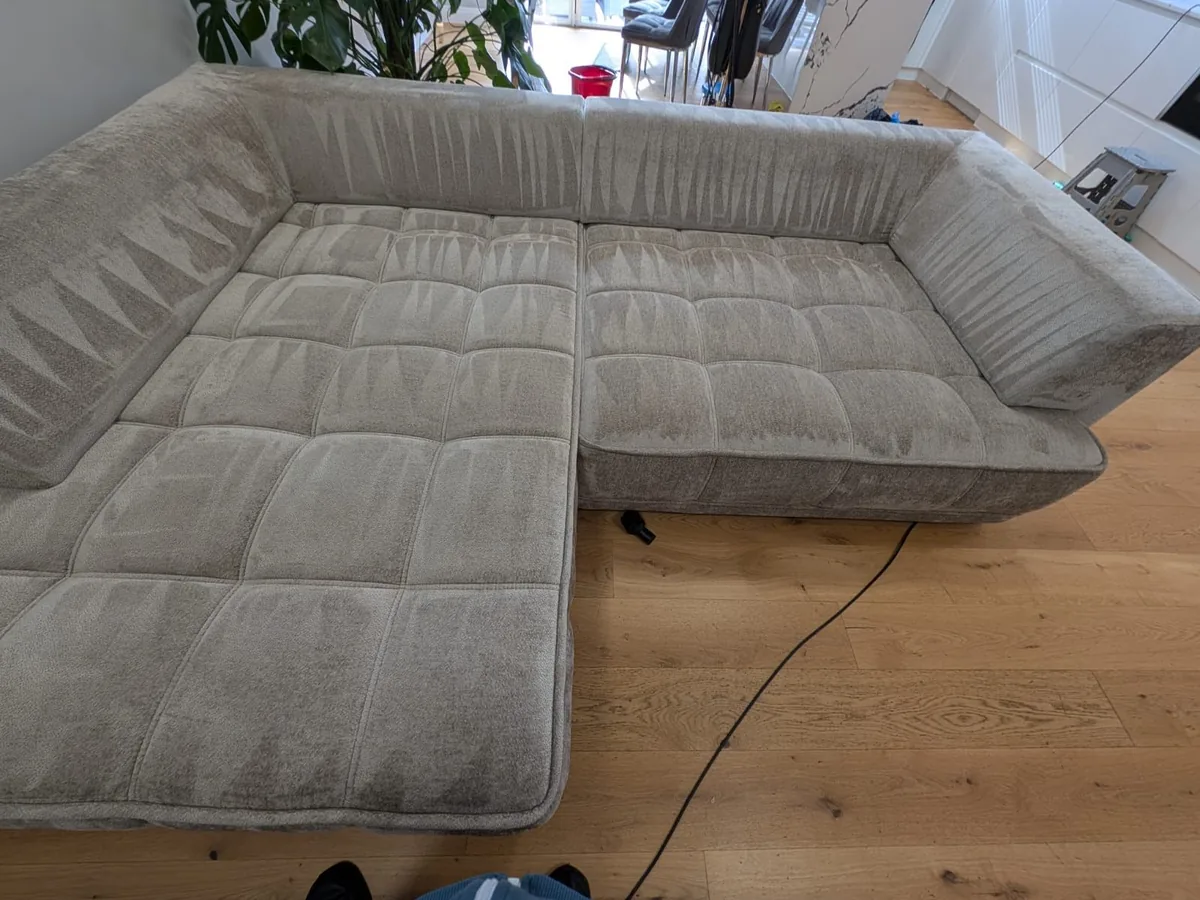 Large fabric corner sofa being deep cleaned